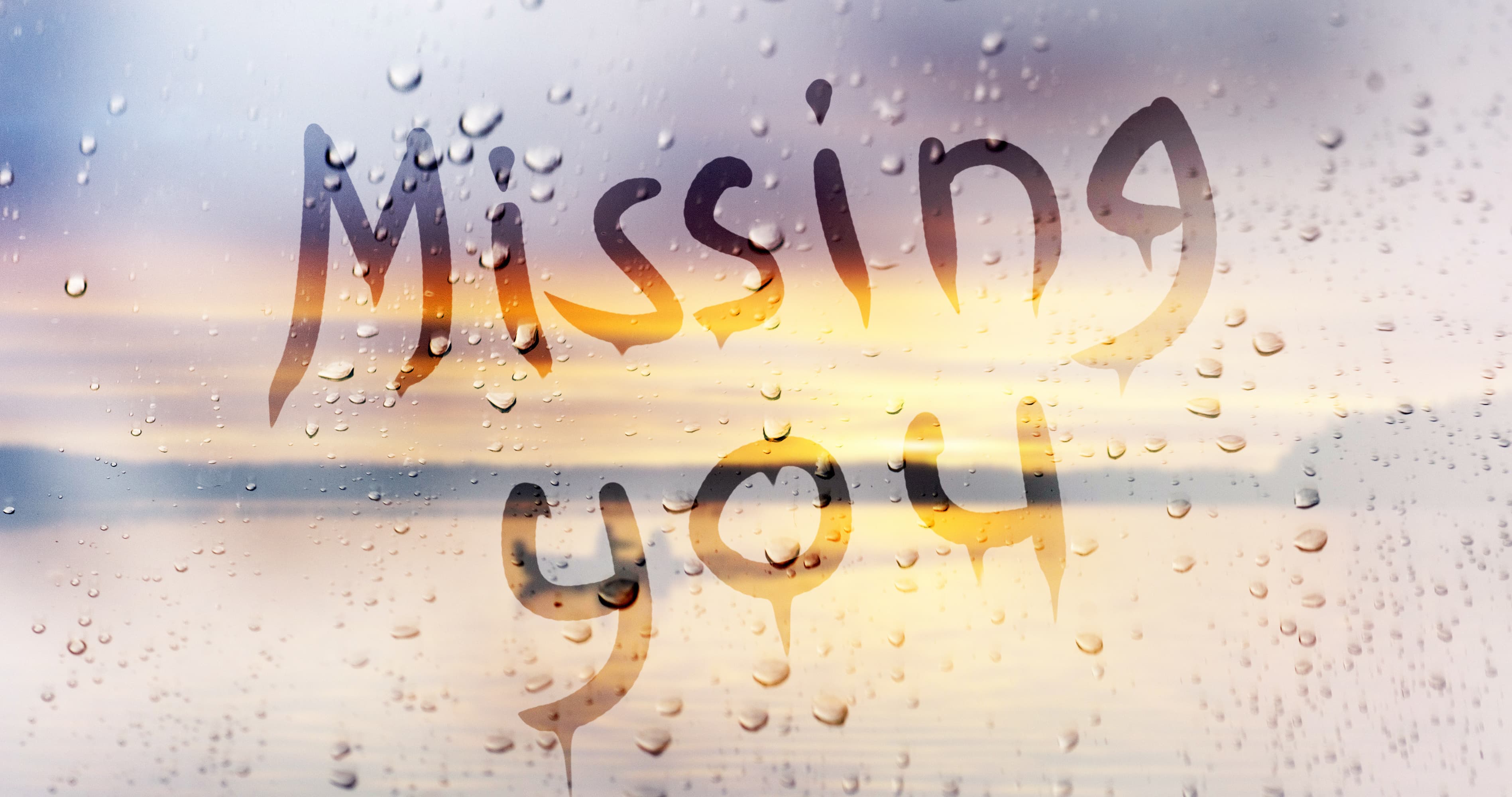 Missing you message written on a rainy window, representing texts to make him miss you and feelings of love, longing, and emotional connection.