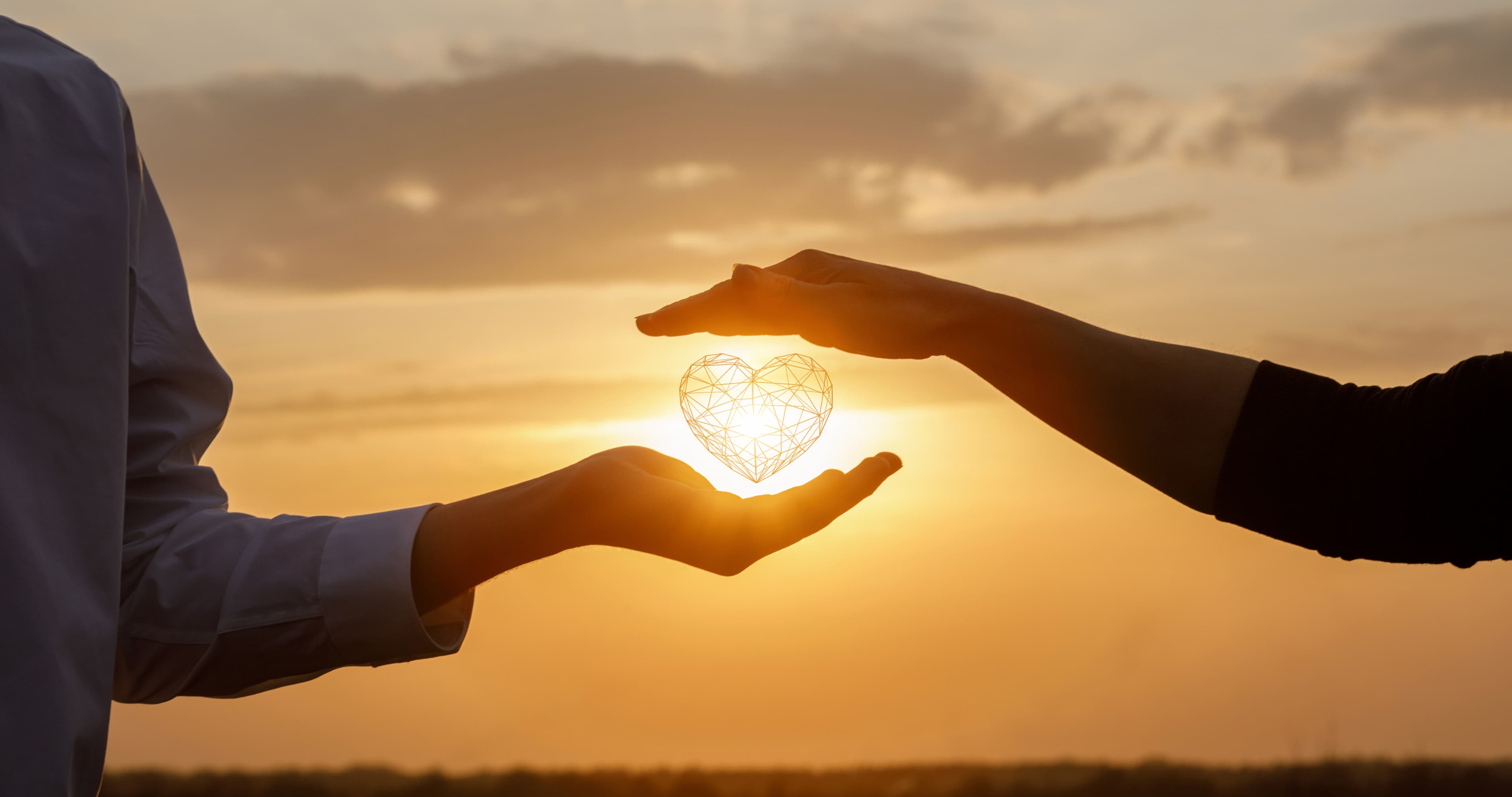 Couple holding a glowing heart between their hands at sunset, representing how to fix communication in a relationship, build trust, improve emotional connection, and create healthier love.