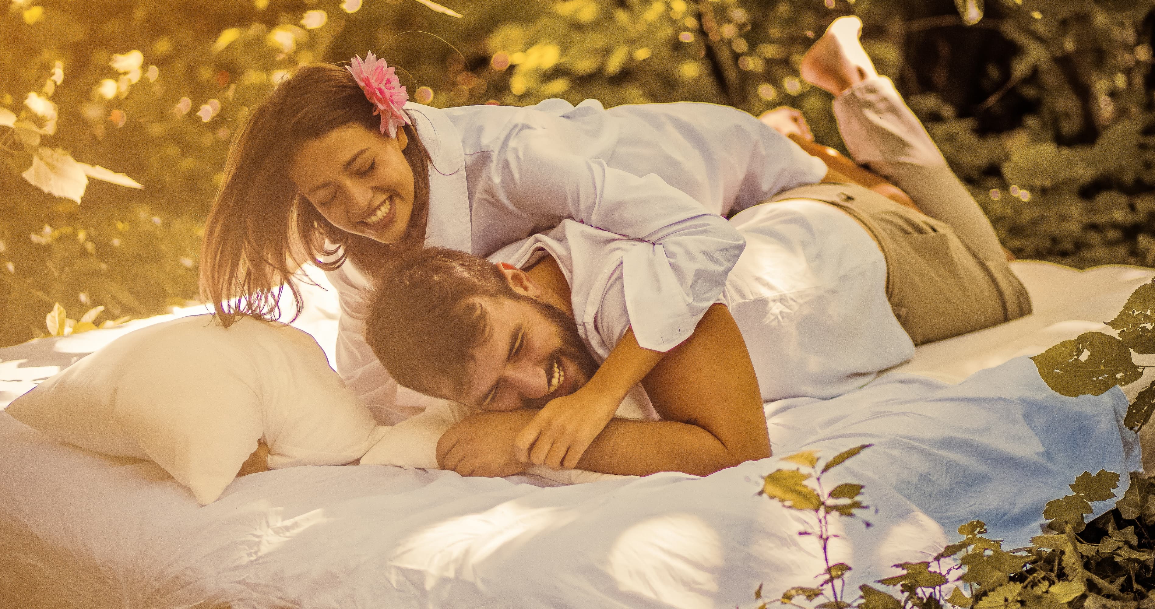 Happy married couple smiling together on an outdoor bed, showing love, intimacy, and how to rebuild your marriage.