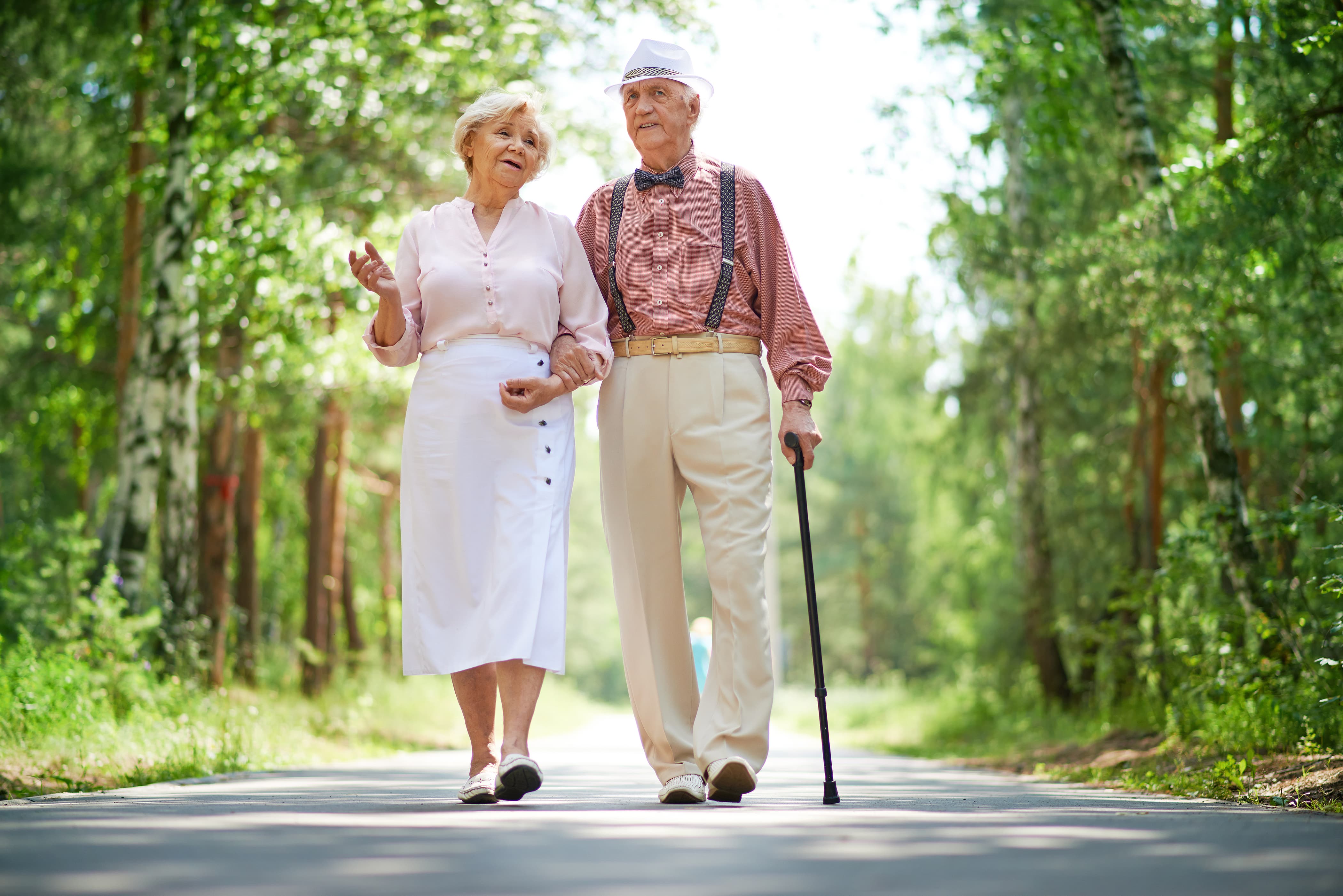 Elderly couple walking together on a peaceful path, showing how to build a long-lasting relationship through love, patience, and commitment.